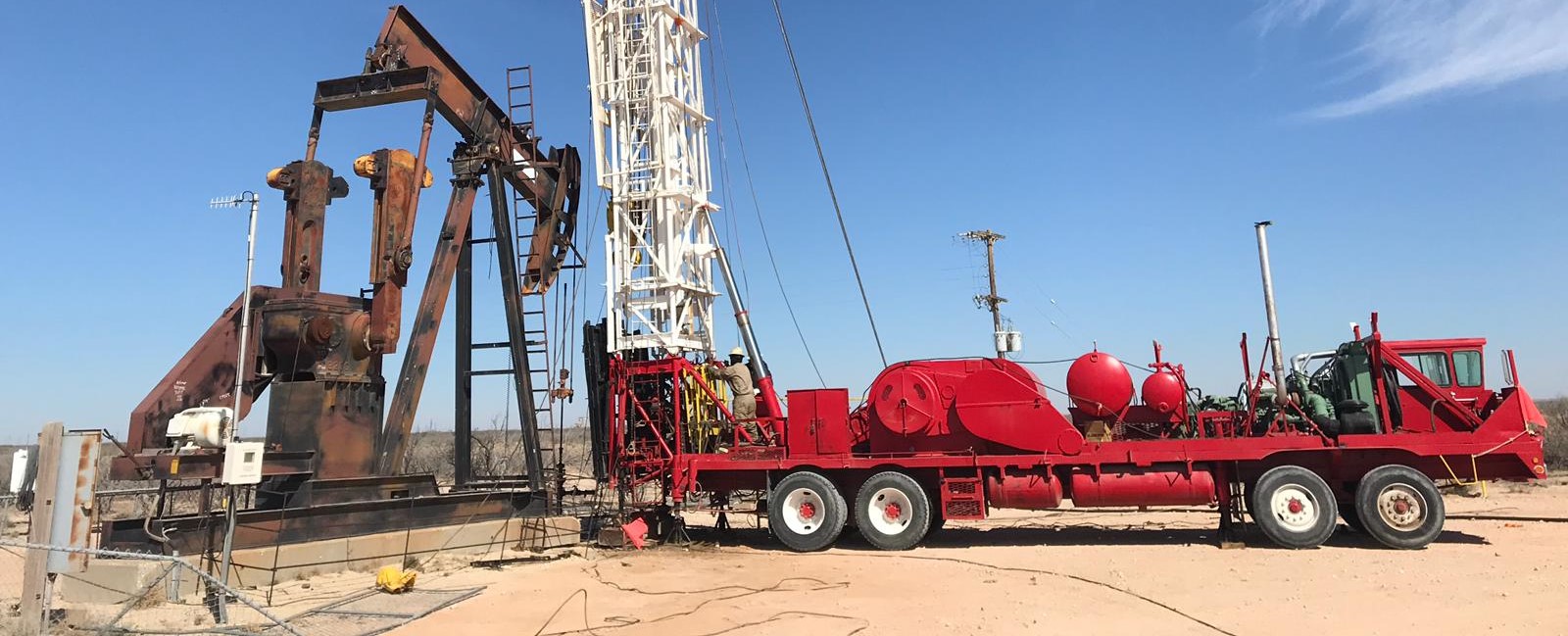 Workover rig and producing pumping unit during field execution